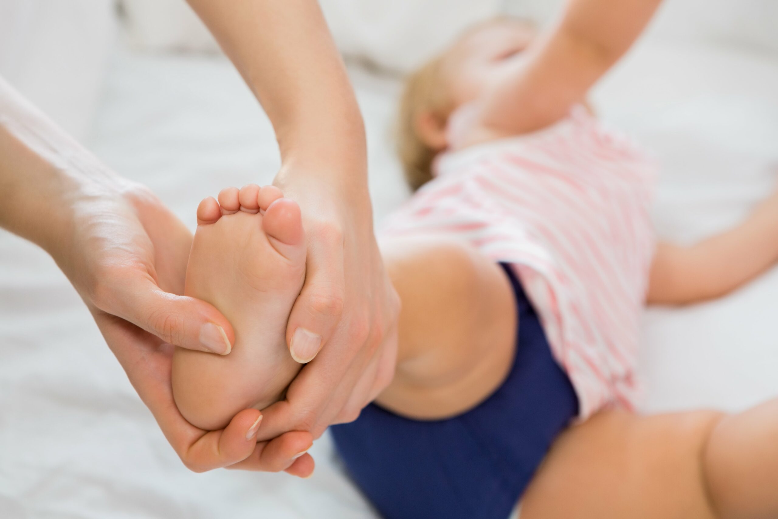 baby-girl-receiving-massage-from-mother-min